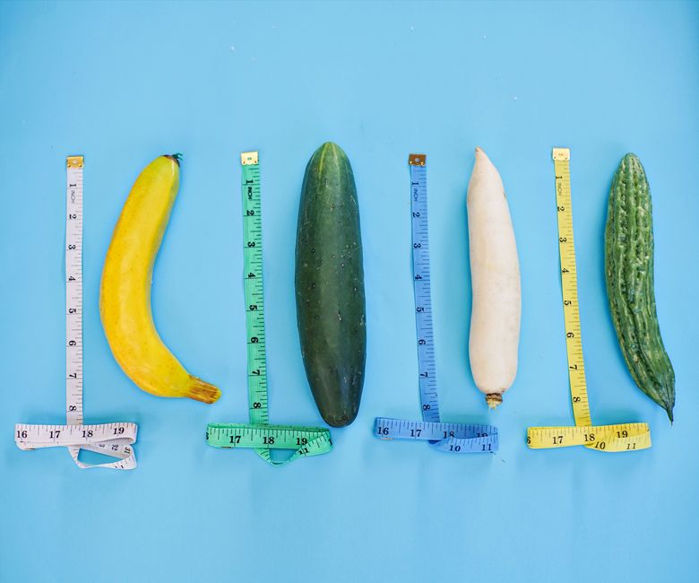 A vibrant still life of various vegetables and measuring tapes on a blue backdrop.