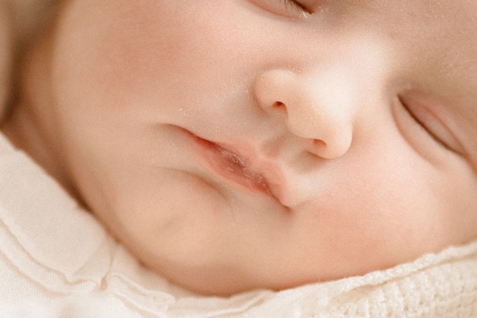Close-up of a peacefully sleeping baby with eyes closed, showcasing soft features and serene expression.