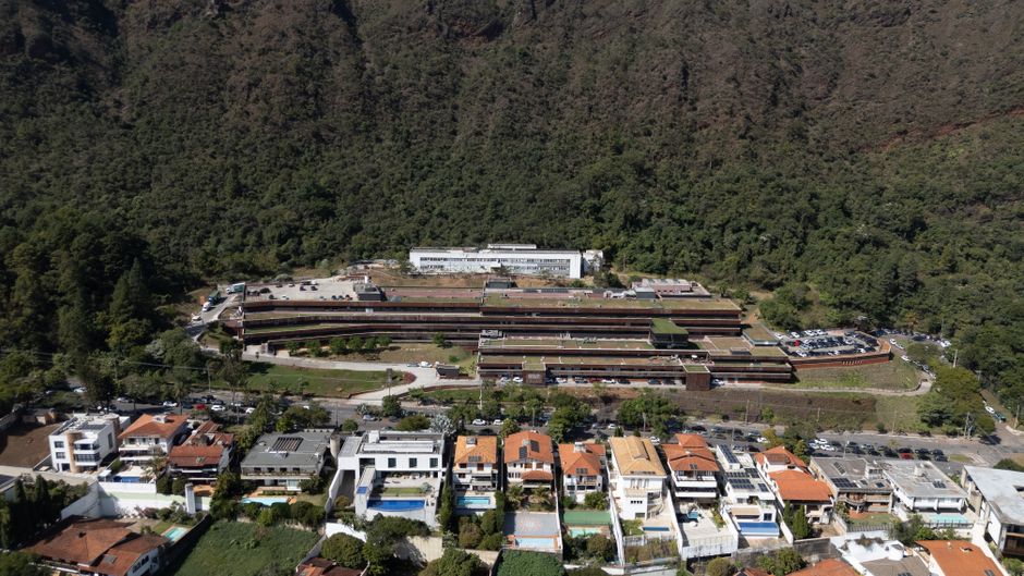 Aerial photograph of a residential area in Belo Horizonte, Brazil, surrounded by lush greenery.