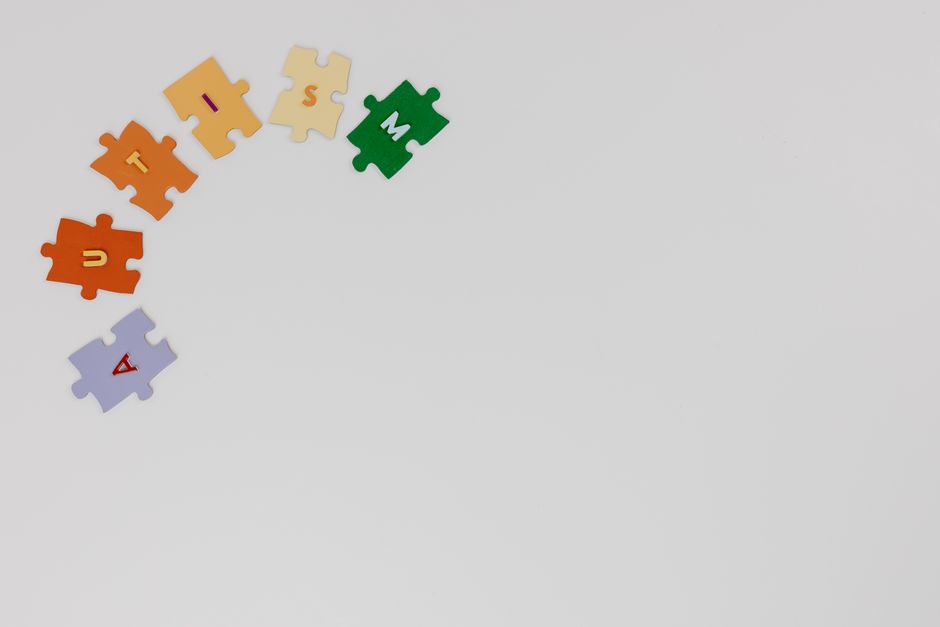 Puzzle pieces spelling autism on a white background, symbolizing autism awareness.