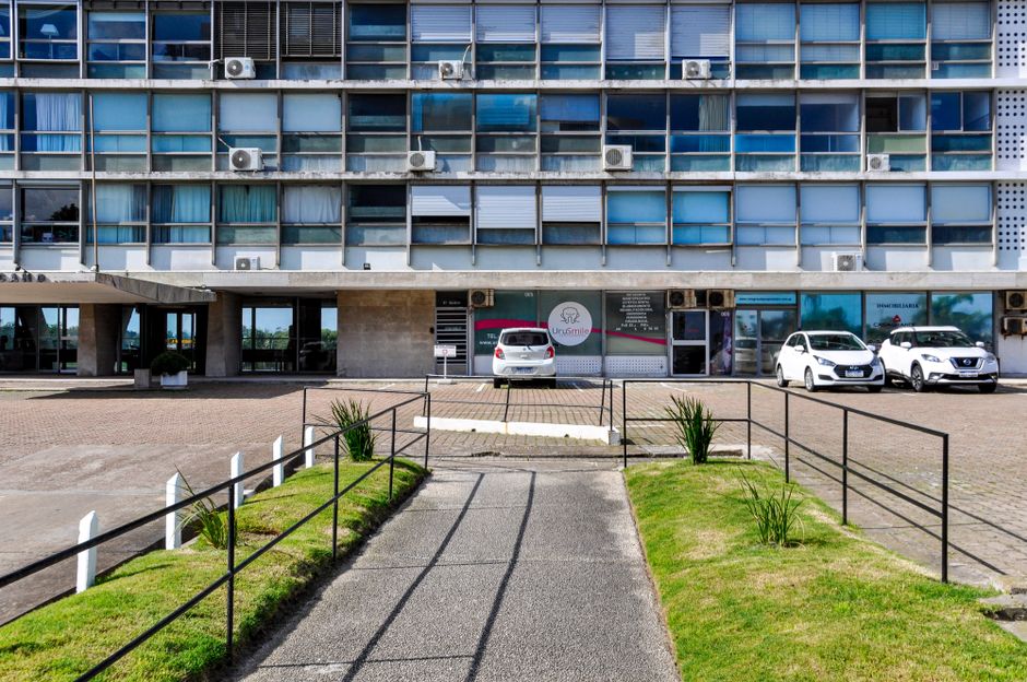 Street view of a modern office building in Montevideo, Uruguay with parked cars.
