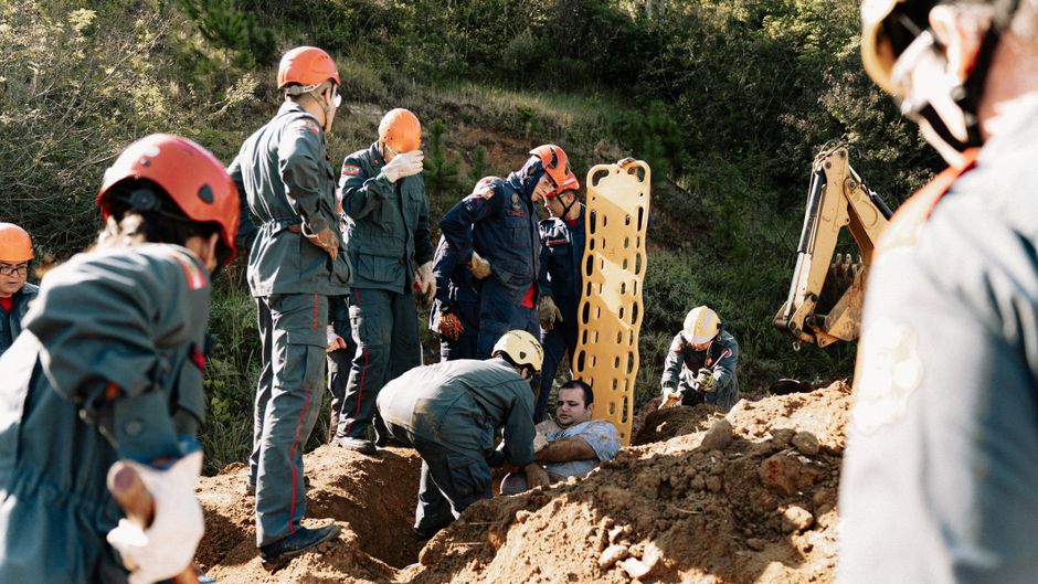Emergency responders conducting a rescue simulation outdoors, showcasing teamwork and safety measures.