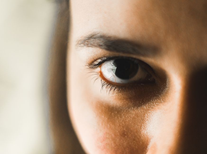 Intimate close-up of a woman's eye, focusing on natural details and emotions.
